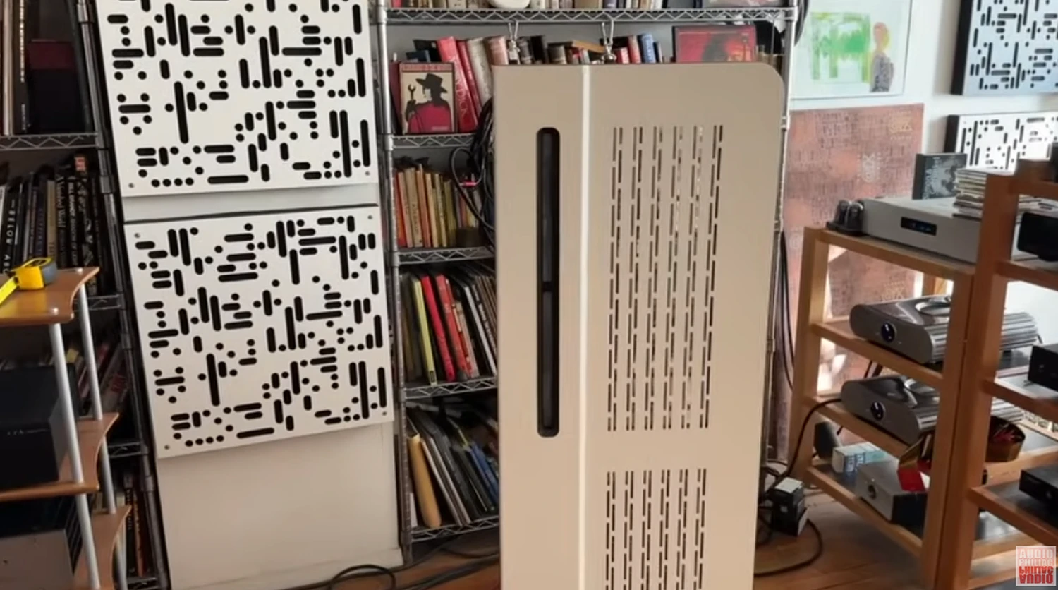 Vue d'un panneau Diptyque dp140 mkII avec des absorbants au mur, des électroniques dans des meubles en bois à droite et des vinyles en fond