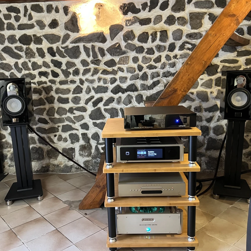 Marten Parker Duo piano black dans une pièce en pierres avec un escalier en bois