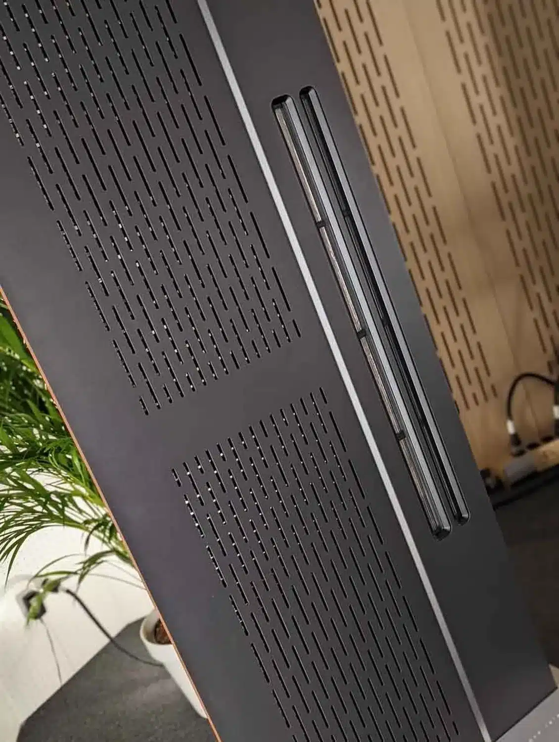 Gros plan sur un panneau électromagnétique gris foncé Diptyque Audio Référence avec des fentes verticales sur les membranes de medium grave et fentes plus larges pour celle des aigus (par 1877.audio)