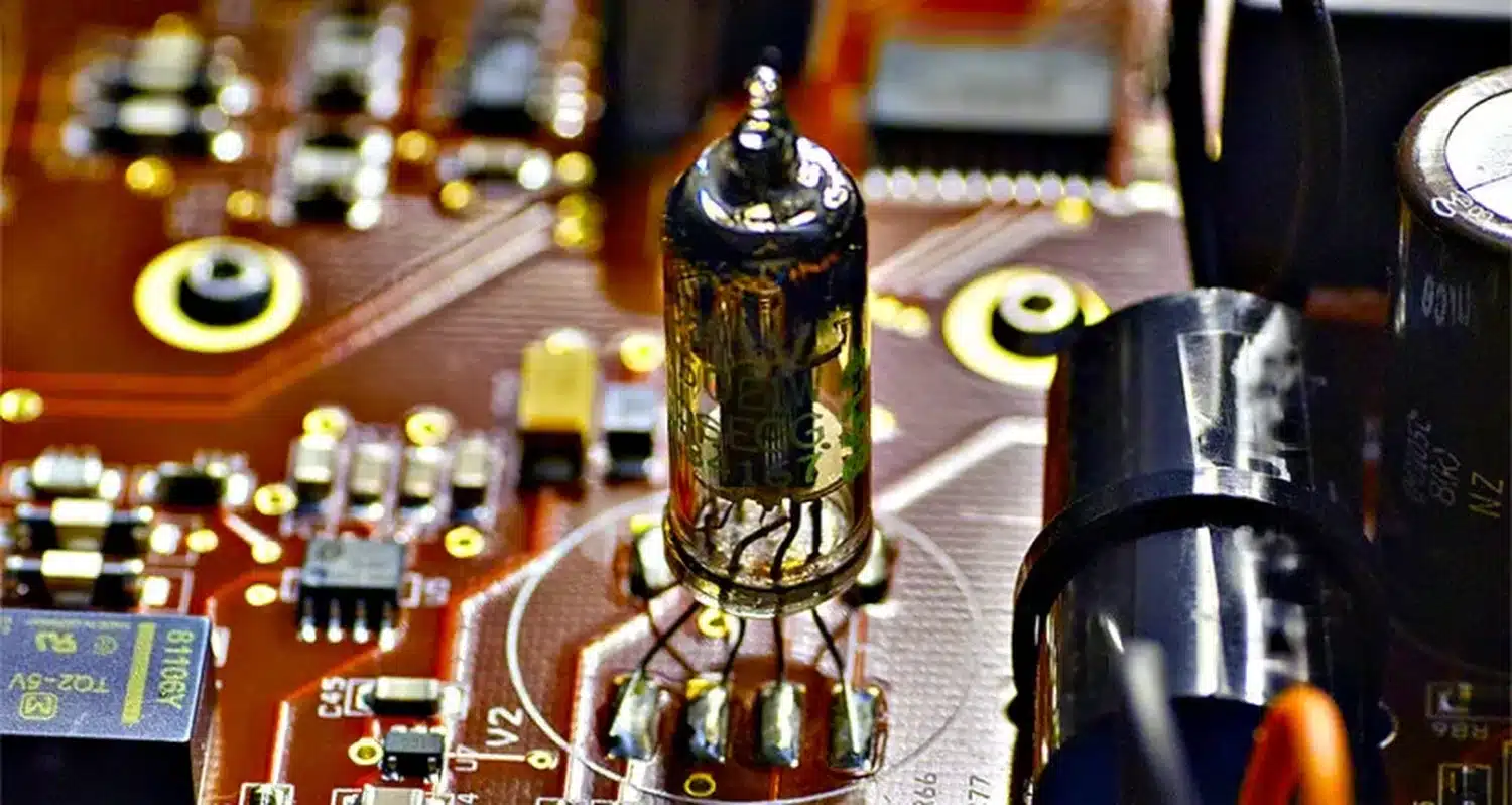 Gros plan d'un tube à vide du Vermeer Audio Two soudé sur un circuit imprimé entouré de condensateurs et de micropuces (par 1877.audio)