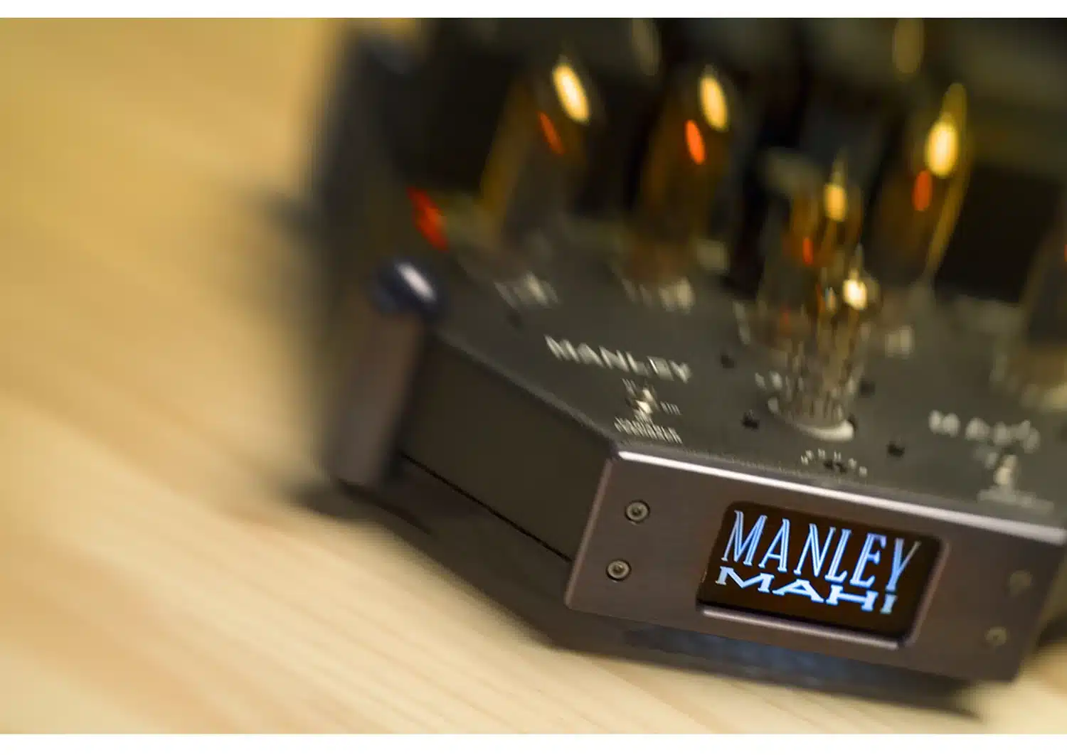 Gros plan sur l'amplificateur à tubes Manley Mahi avec un focus sur le logo, avec un arrière-plan légèrement flou des boutons de commande et des tubes (par 1877.audio)